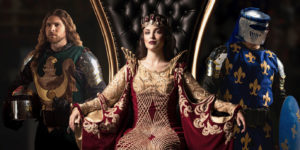 The queen seated at her throne with the green and blue knight standing behind her.