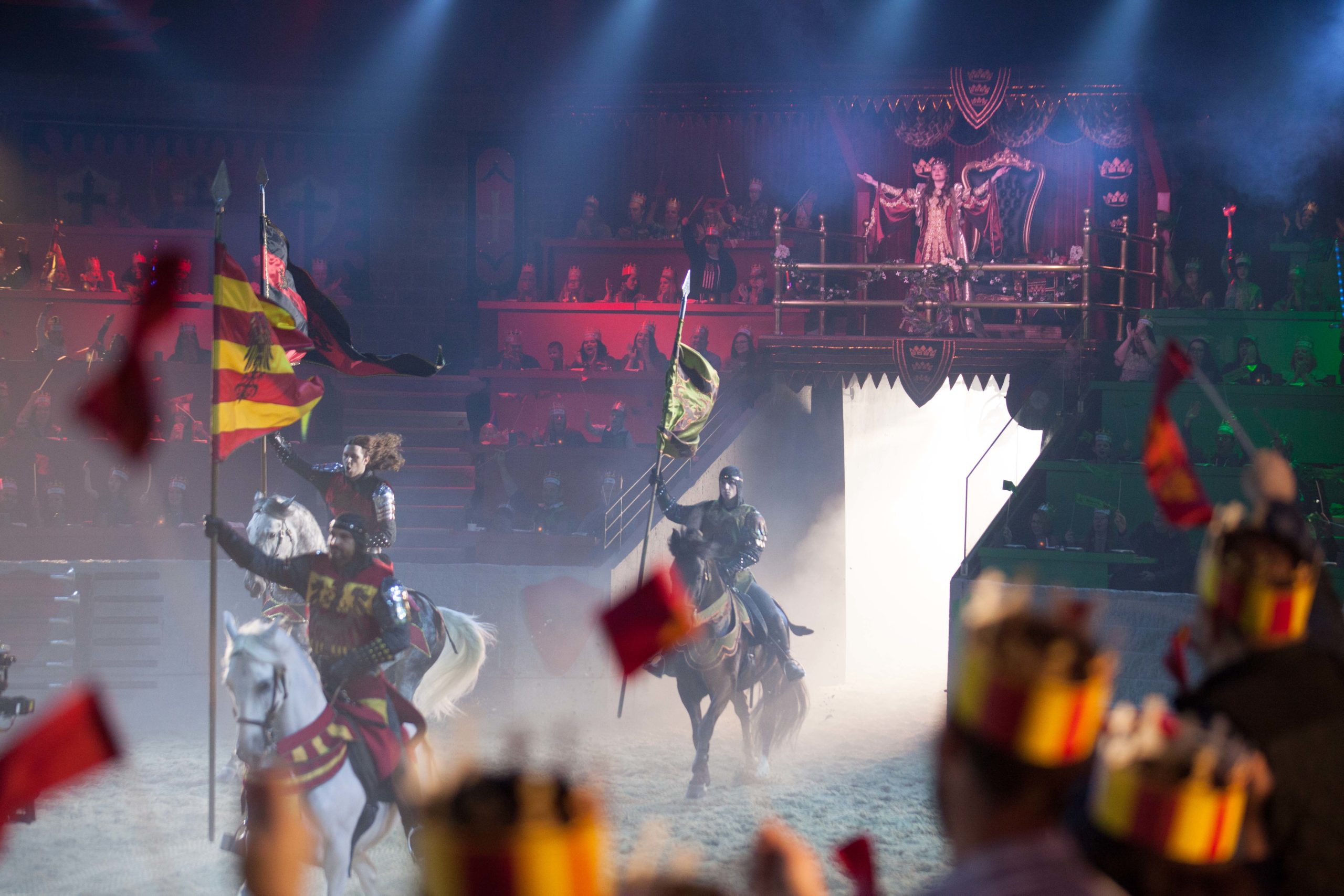 The Queen greets an arena full of guests as knights charge out